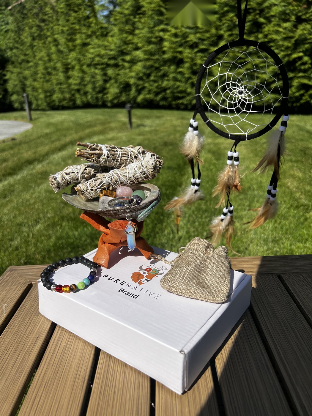 Full PureNative smudge kit laid out: sage, shell, stones, bracelet and dreamcatcher